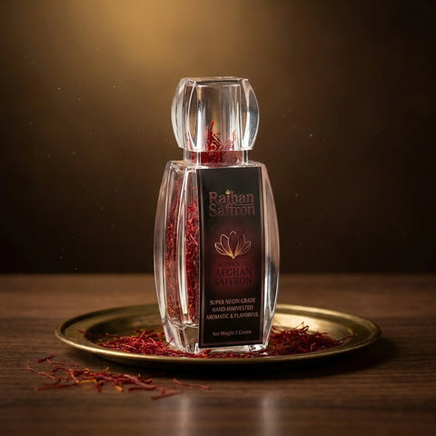 Raihan Saffron premium Afghan Super Negin saffron threads in a crystal glass bottle on an antique brass tray with loose all-red saffron threads — luxury studio product photograph